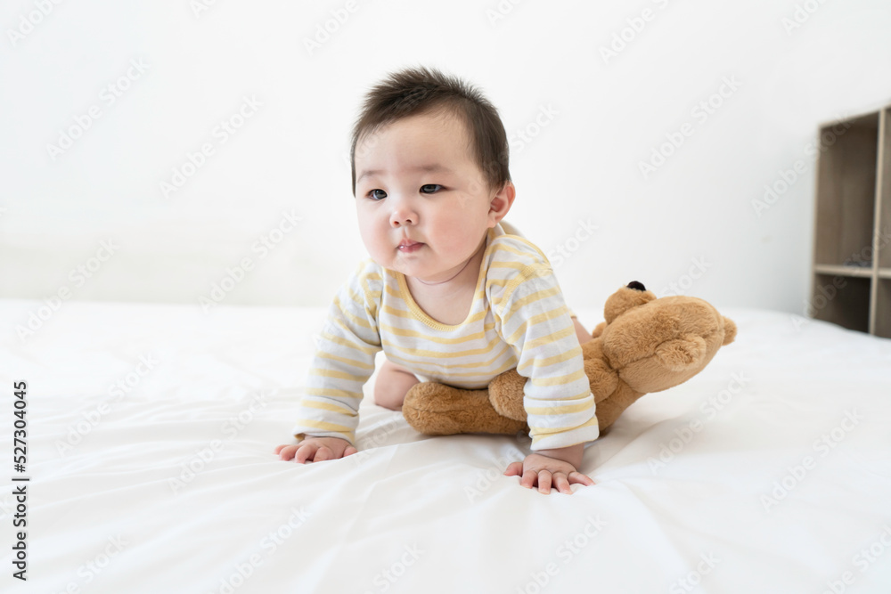 Portrait of cute little asian baby girl wearing bodysuit lying on white beedsheets at home. Portrait of cute little asian baby girl wearing bodysuit lying on white beedsheets at home.