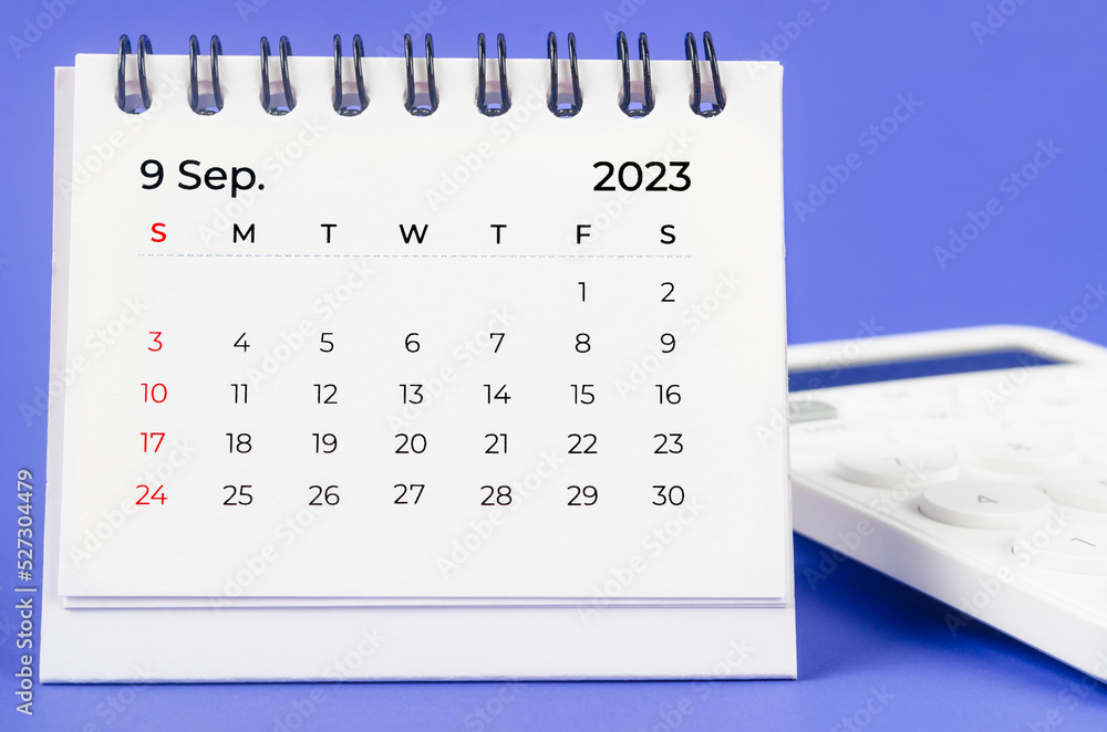 The September 2023 Monthly desk calendar for 2023 year with calculator on purple background. The September 2023 Monthly desk calendar for 2023 year with calculator on purple background.
