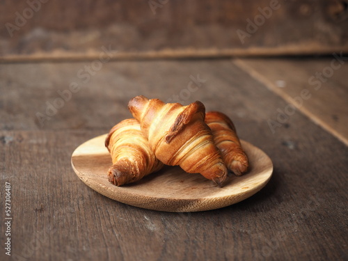 Golden brown baked homemade French butter croissants on wooden plate