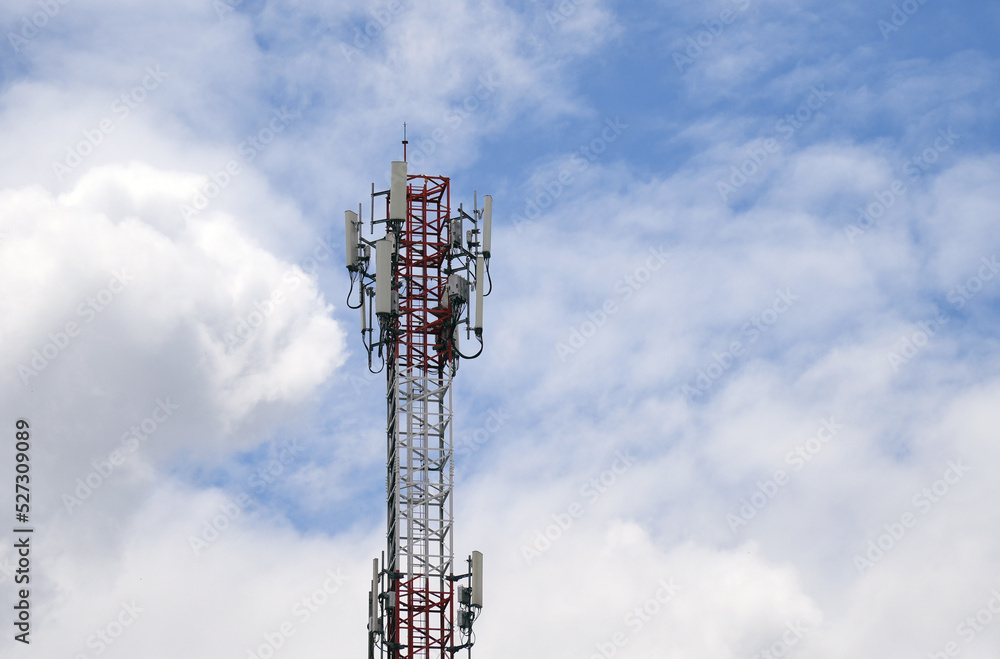 Telecommunication tower of 4G and 5G cellular. Macro Base Station. 5G radio network telecommunication equipment with radio modules and smart antennas mounted on a metal against cloulds sky background