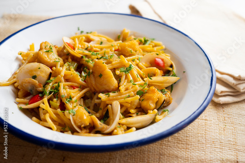 Noodles with monkfish and red peppers. Traditional tapa cooked in paella. Spanish original recipe.