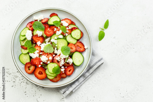 Low carb healthy cucumber strawberry goat cheese salad on plate. Top view, flat lay, copy space.