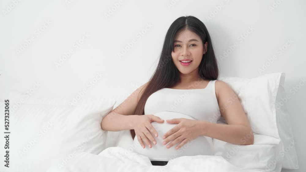 Asian happy pregnant woman is sitting on bed and and touching her belly. pregnancy, motherhood, people and expectation concept
Asian happy pregnant woman is sitting on bed and and touching her belly. pregnancy, motherhood, people and expectation concept