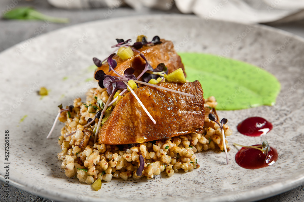 Roasted beef tongue with green buckwheat and green sauce. Main course ...