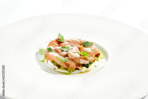 Restaurant dish - shrimp tartare with avocado, cream cheese, sweet chilli sauce on white plate. Ceviche with marinated prawn, avocado and spicy vegetables. Prawn tartare isolated on white background