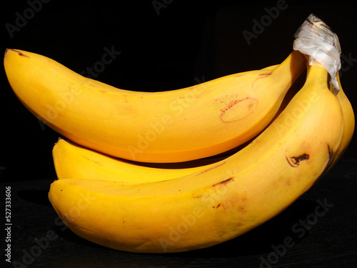 Bananas Plátanos frescas amarillas sobre fondo negro