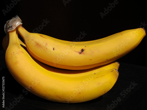 Bananas Plátanos frescas amarillas sobre fondo negro