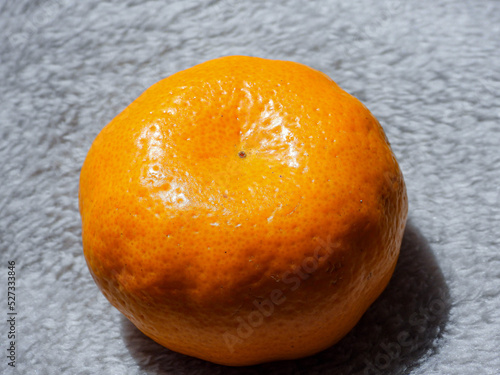 Mandarina anaranjada sobre fondo claro