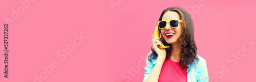 Fotografiet Colorful portrait of funny young woman calling on banana phone looking away on p
