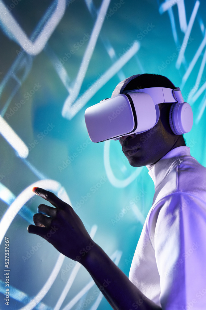 Serious black man touching large screen while exploring virtual reality ...