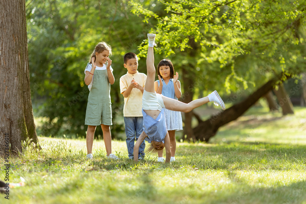 Fototapeta premium Group of asian and caucasian kids having fun in the park