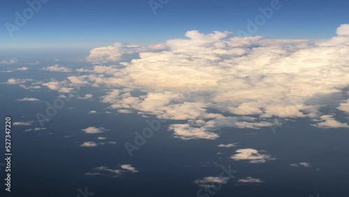 Aerial airplane view on the clouds, engine and Ryanair logo on the airplane wing. View from inside the plane on white clouds