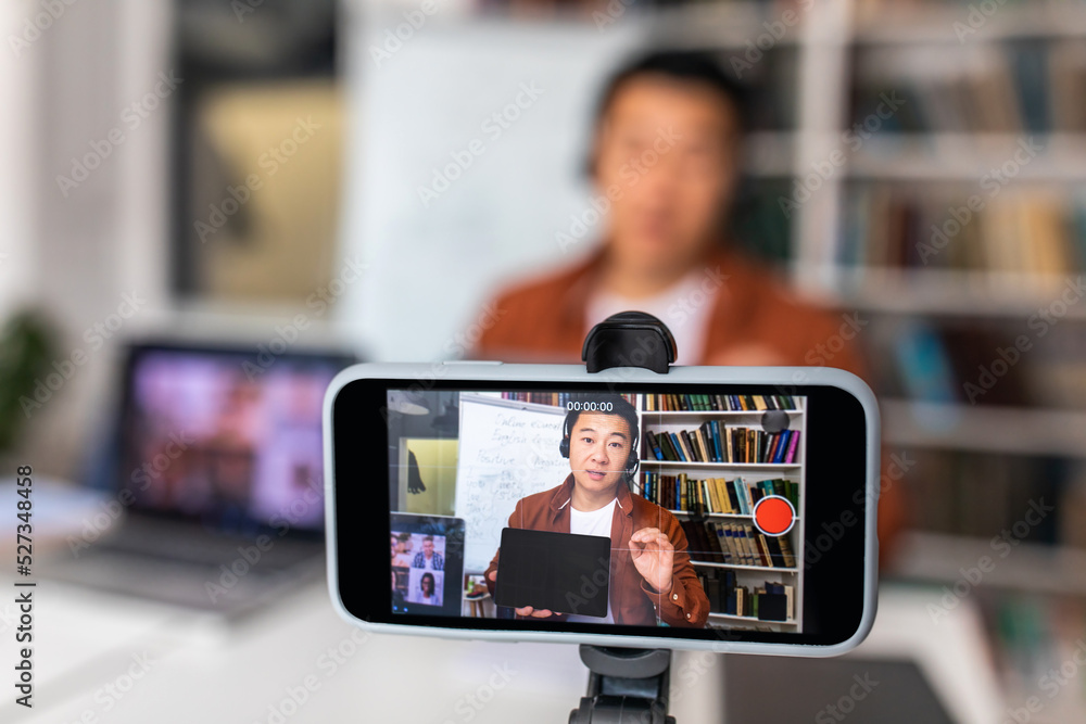 Closeup Of Smartphone With Asian Teacher Man On Screen Indoor Closeup Of Smartphone With Asian Teacher Man On Screen Indoor