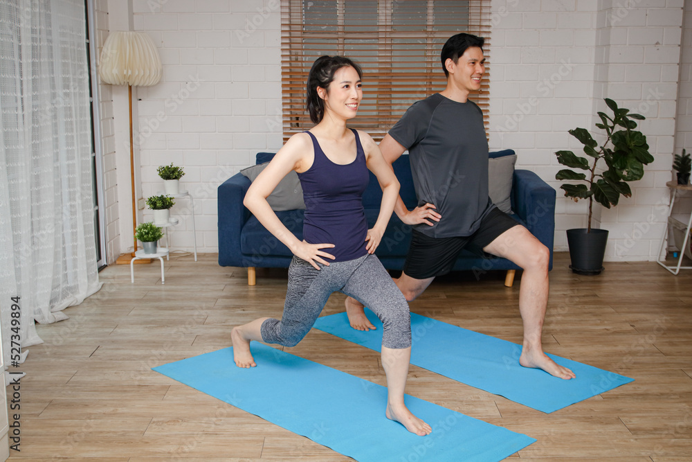 Naklejka premium Asian couple exercising together at home. family concept Exercise for health.