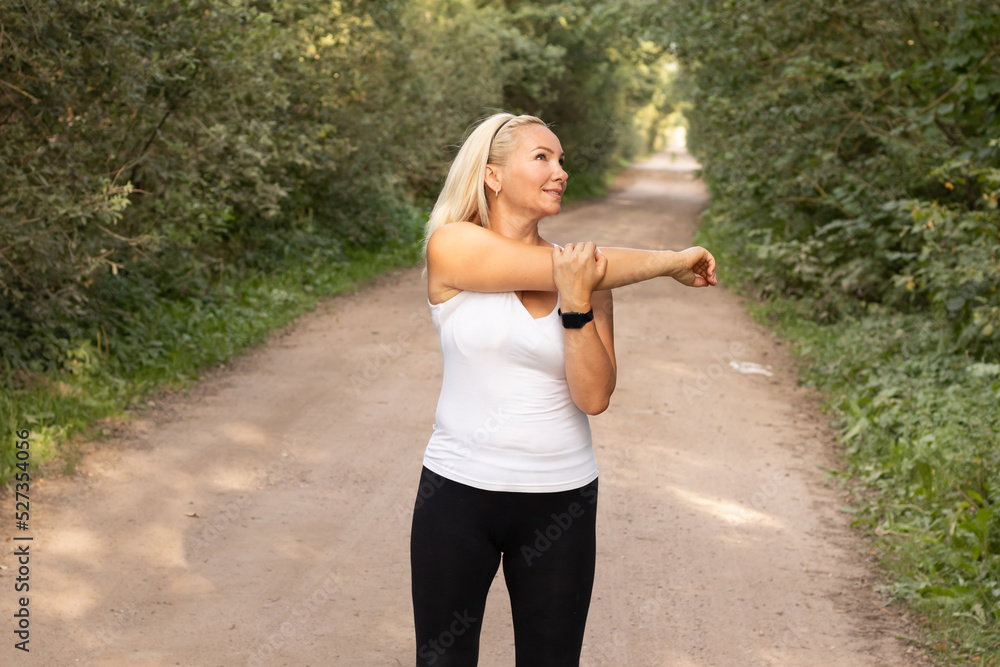 a young beautiful girl is warming up before jogging through the forest on a hot summer day Healthy lifestyle a young beautiful girl is warming up before jogging through the forest on a hot summer day Healthy lifestyle