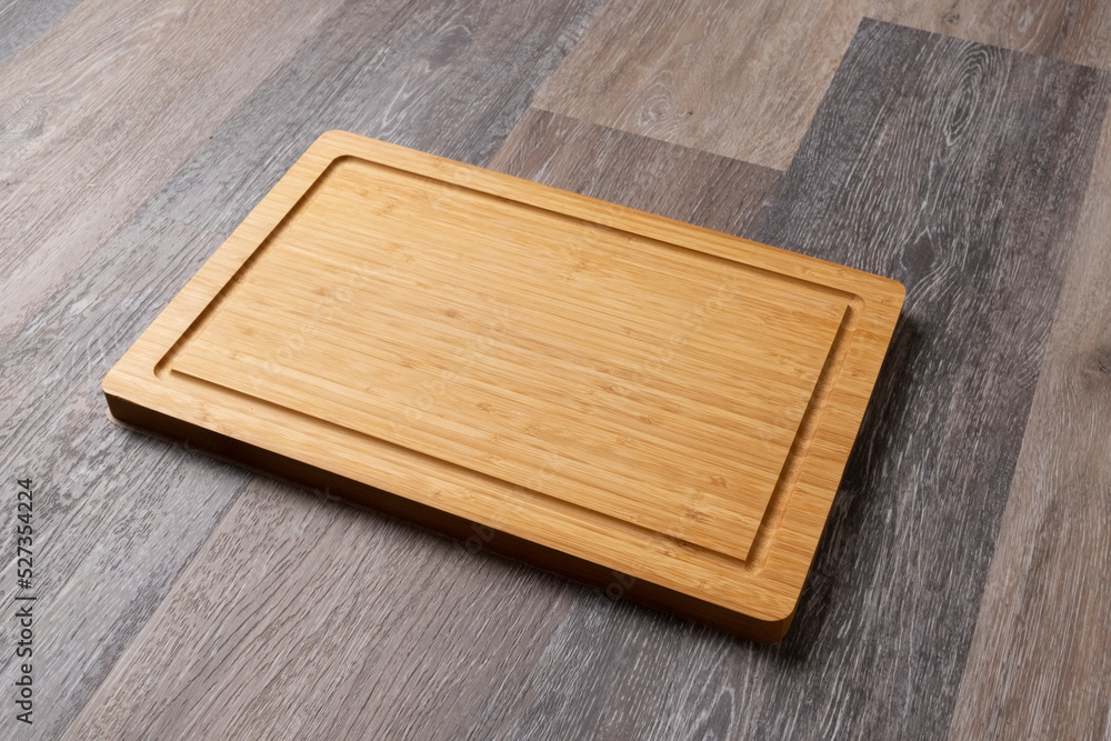Empty cutting board on a wooden table, close-up, copy space for text. Empty cutting board on a wooden table, close-up, copy space for text.