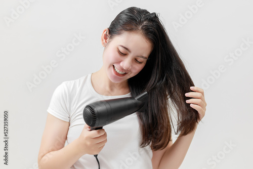 Happy Asian young woman drying hair on white background, Treatment hair concept, Damaged hair, Beauty salon.