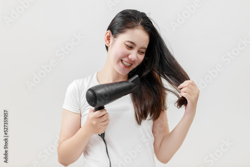Happy Asian young woman drying hair on white background, Treatment hair concept, Damaged hair, Beauty salon.
