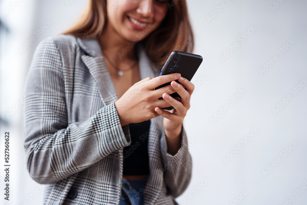Close-up of a woman using a smartphone to work on various application including mobile transaction to send messages, LINE, and various business information sent via social media. Close-up of a woman using a smartphone to work on various application including mobile transaction to send messages, LINE, and various business information sent via social media.