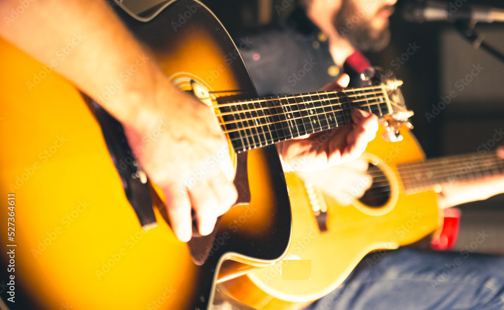 Obraz premium Musicians playing acoustic guitars in cottage at night