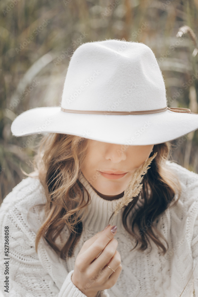 blonde girl in a white hat walks along the seashore on an autumn day blonde girl in a white hat walks along the seashore on an autumn day