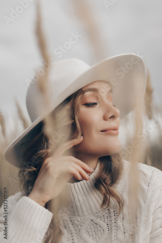 blonde girl in a white hat walks along the seashore on an autumn day