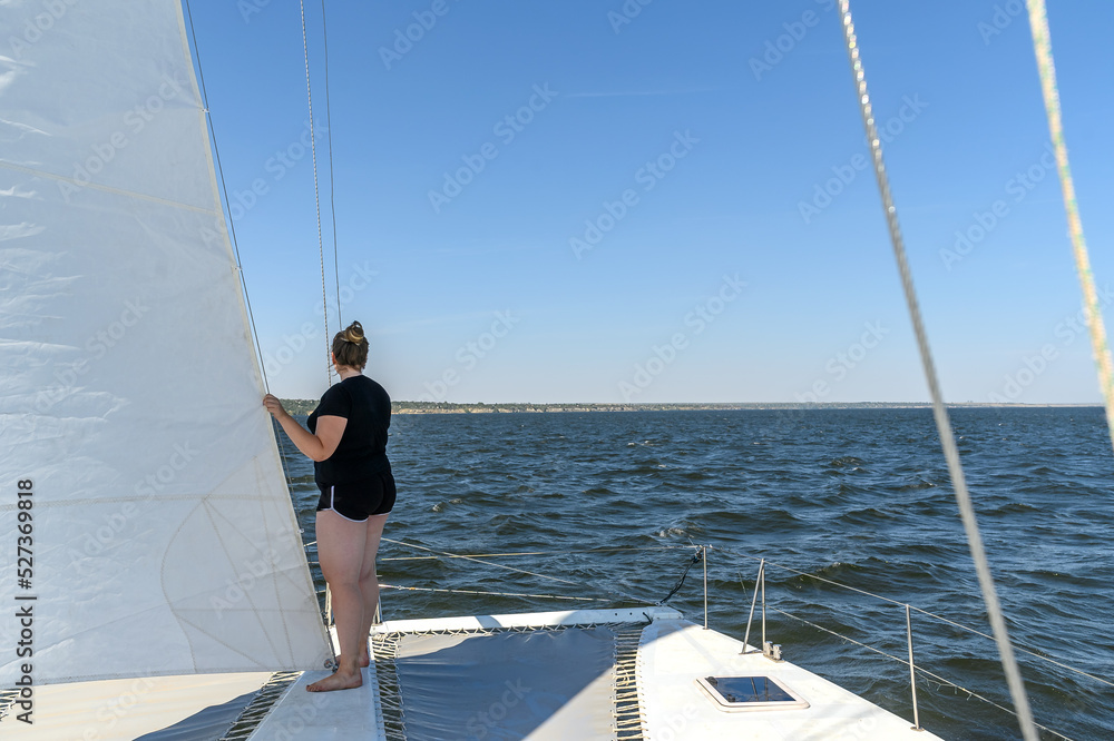 A girl in black clothes on a yacht is resting in the summer. Vacation travel.