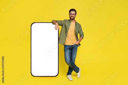 Cuadro en lienzo Full body length of man leaning on big smartphone with empty white screen, stand