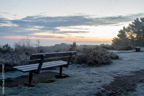 A cold and frosty bench in Winter at sunrise