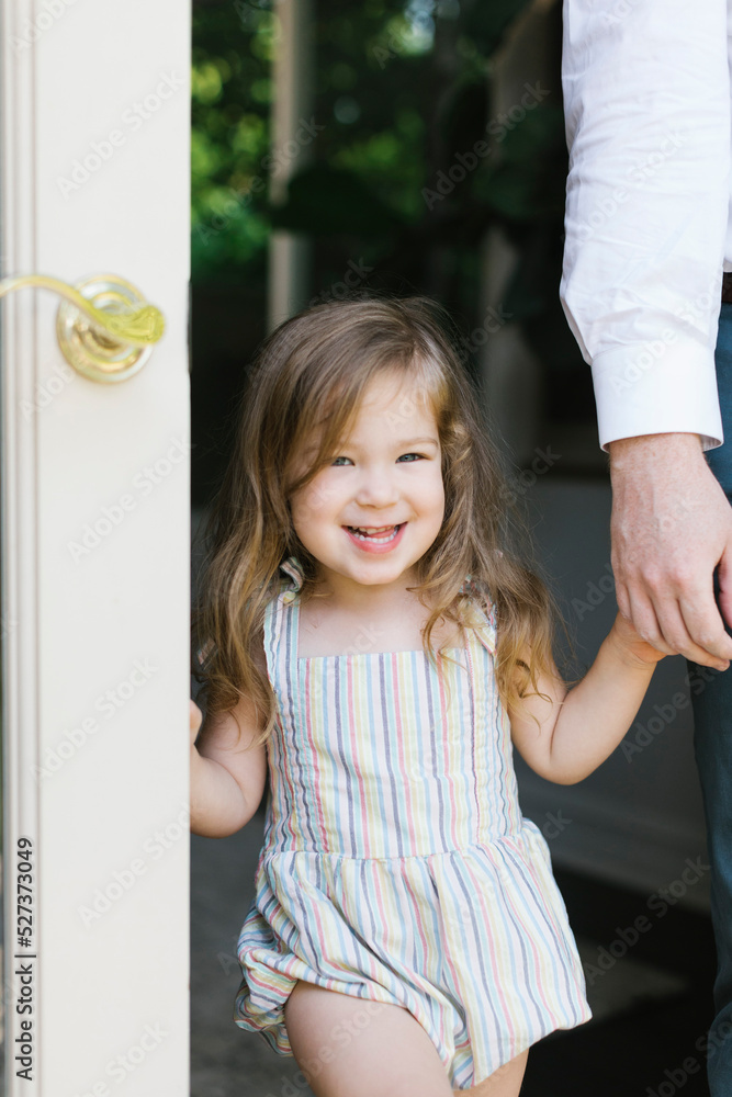 Portrait of smiling girl (2-3) holding fathers hand in doorway at home Portrait of smiling girl (2-3) holding fathers hand in doorway at home