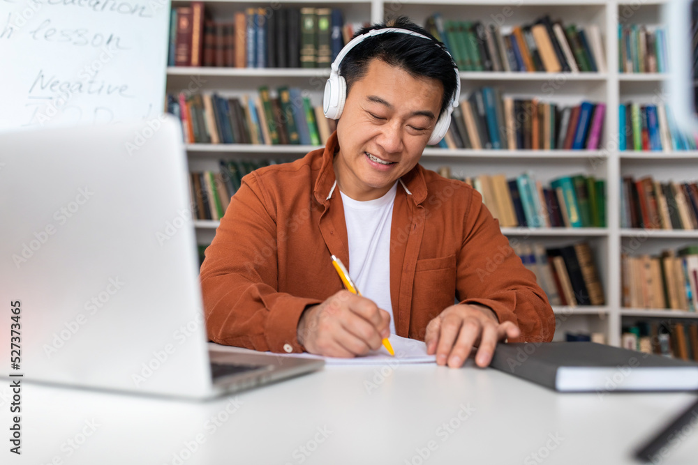 Korean Teacher Man Taking Notes Working On Laptop At Workplace