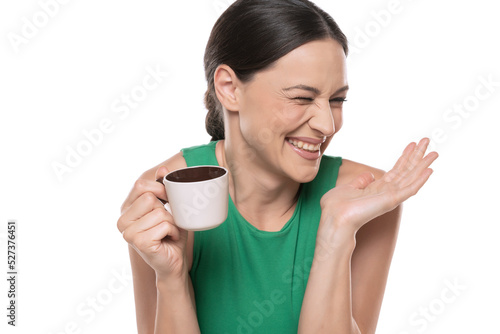 A young happy woman gossips with a cup of coffee in her hand on a white background