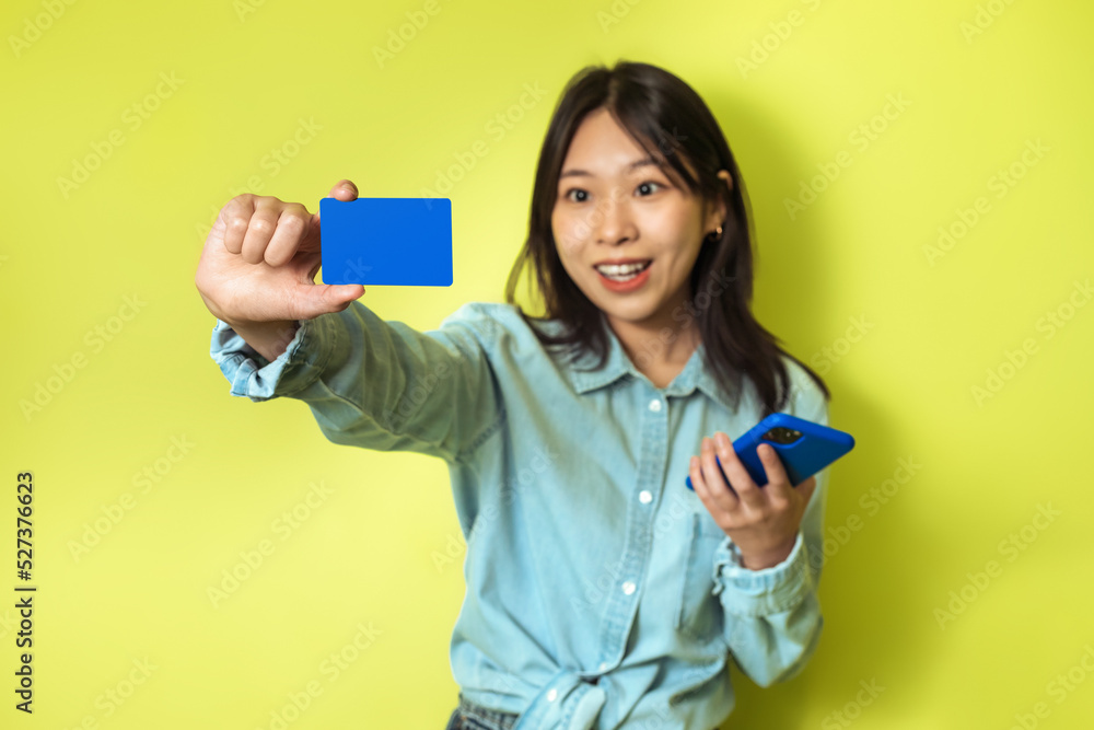 Excited Chinese Lady Shopping Via Smartphone Holding Credit Card, Studio Excited Chinese Lady Shopping Via Smartphone Holding Credit Card, Studio