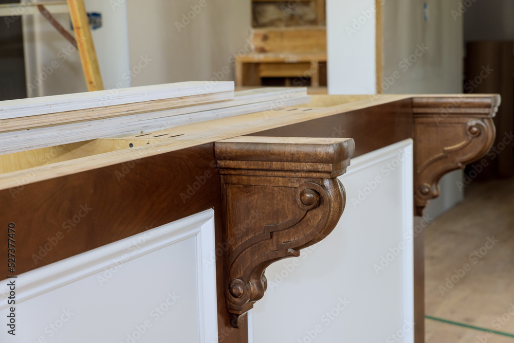 A new kitchen island with wooden corbels has been installed so granite