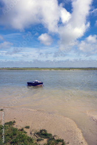Little blue boat on the Bay of Somme on a cloudy spring afternoon, Hauts-de-France, France