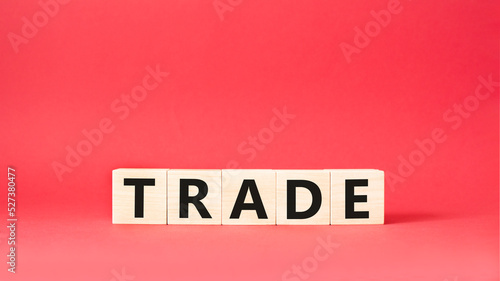 Trade symbol. Wooden cubes with word Trade. Beautiful red background. Trade concept. Copy space.