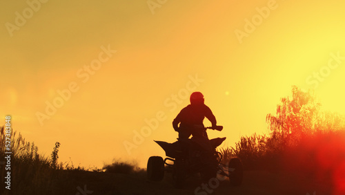 Quad biker jumping in sunset.