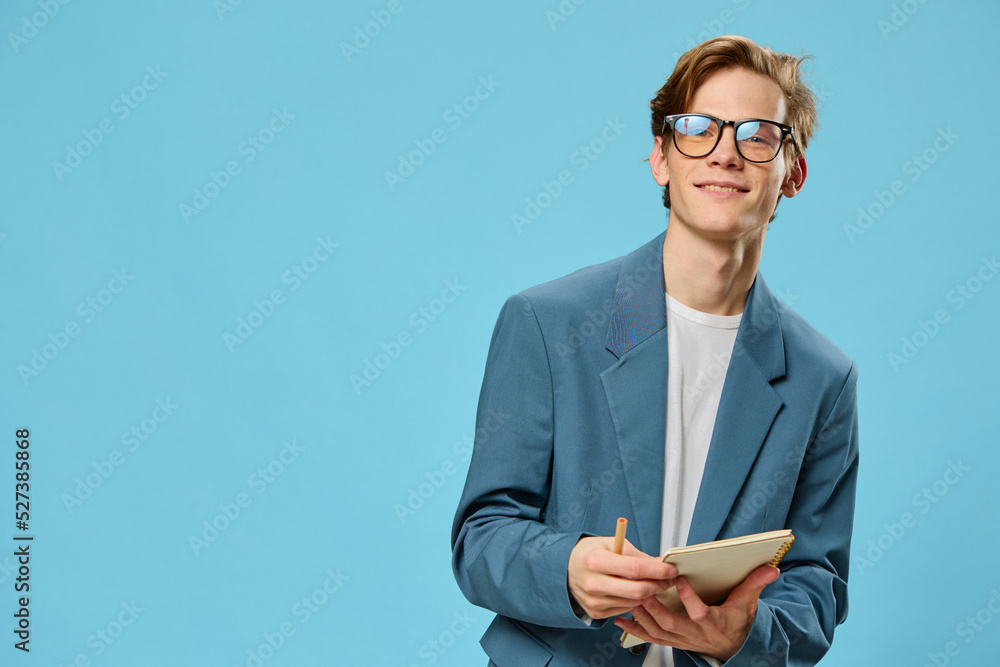 a funny guy in a strict suit for office work is wearing glasses and holding an empty notepad in his hands a funny guy in a strict suit for office work is wearing glasses and holding an empty notepad in his hands