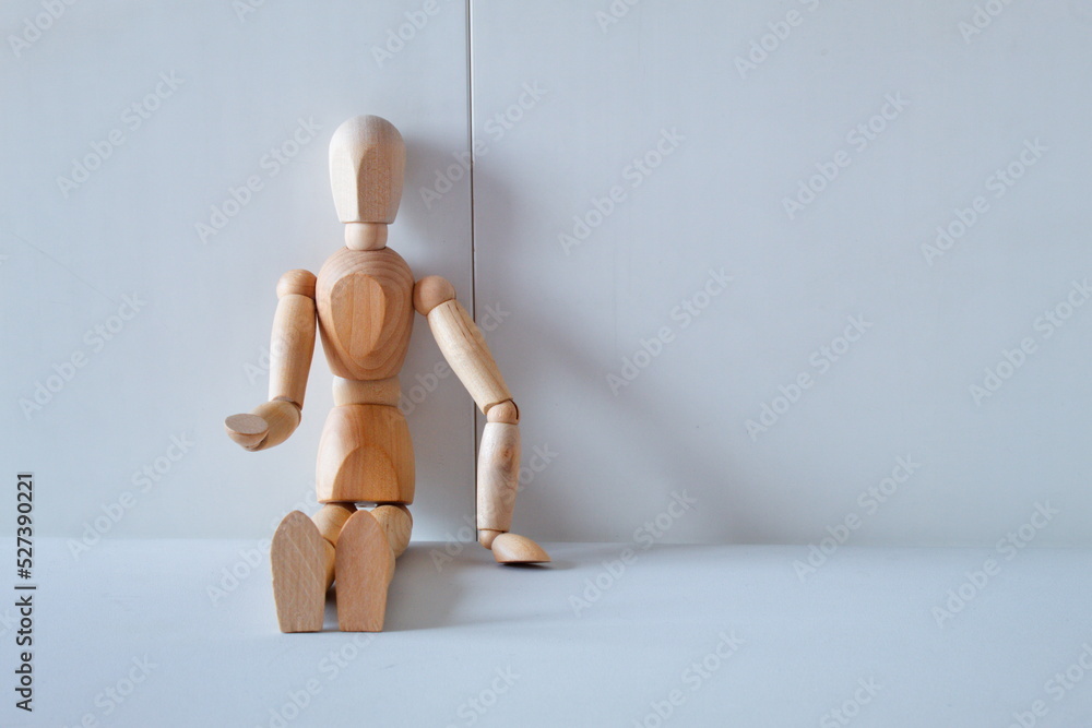 Concept of loneliness, poverty and abandonment with a wooden doll asking as a model Concept of loneliness, poverty and abandonment with a wooden doll asking as a model