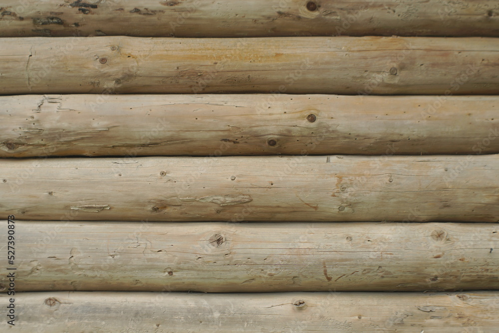 Naklejka premium a wall made of a round wooden beam