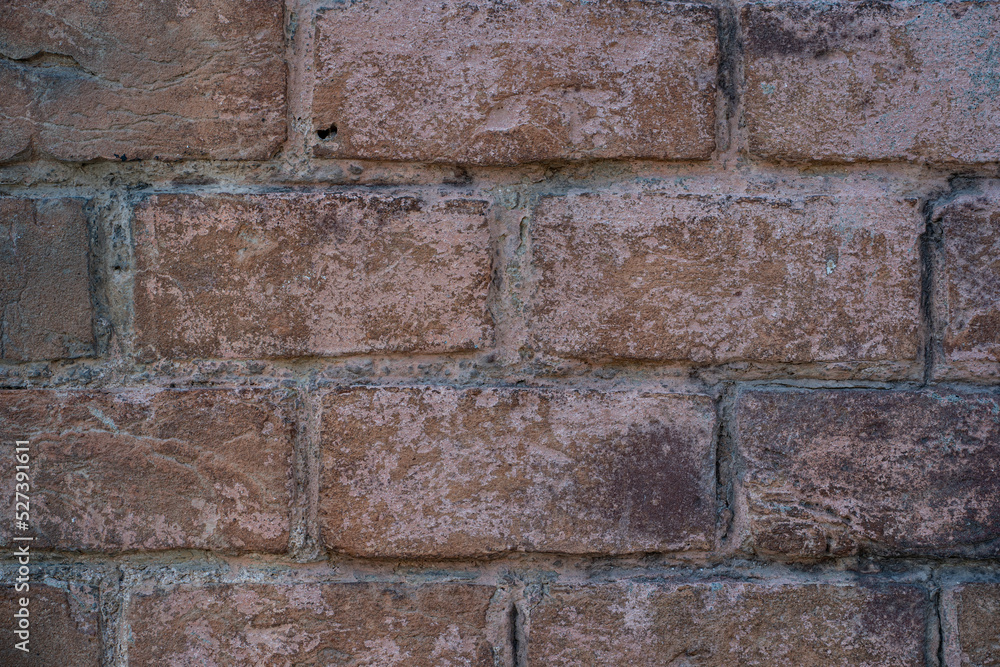 Naklejka premium Old brick wall with ruined bricks. Aged grunge wall background. Vintage Texture. Vertical Web banner or Wallpaper With Copy Space for design.