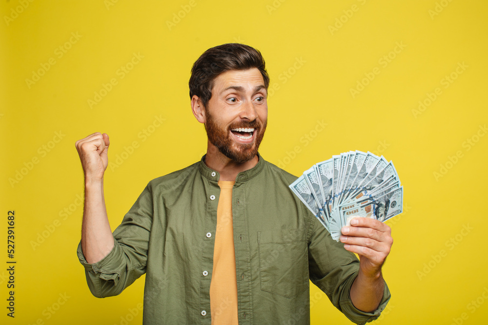 Overjoyed middle aged man holding lots of money, gesturing YES, male with fan of dollars achieving financial success Overjoyed middle aged man holding lots of money, gesturing YES, male with fan of dollars achieving financial success