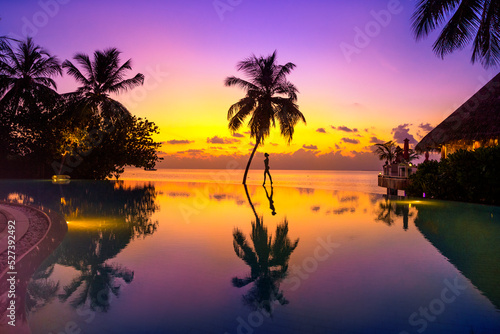 Sunset on Maldives island. Beautiful sky and ocean and beach with palms background for summer vacation holiday and travel concept. © marcink3333