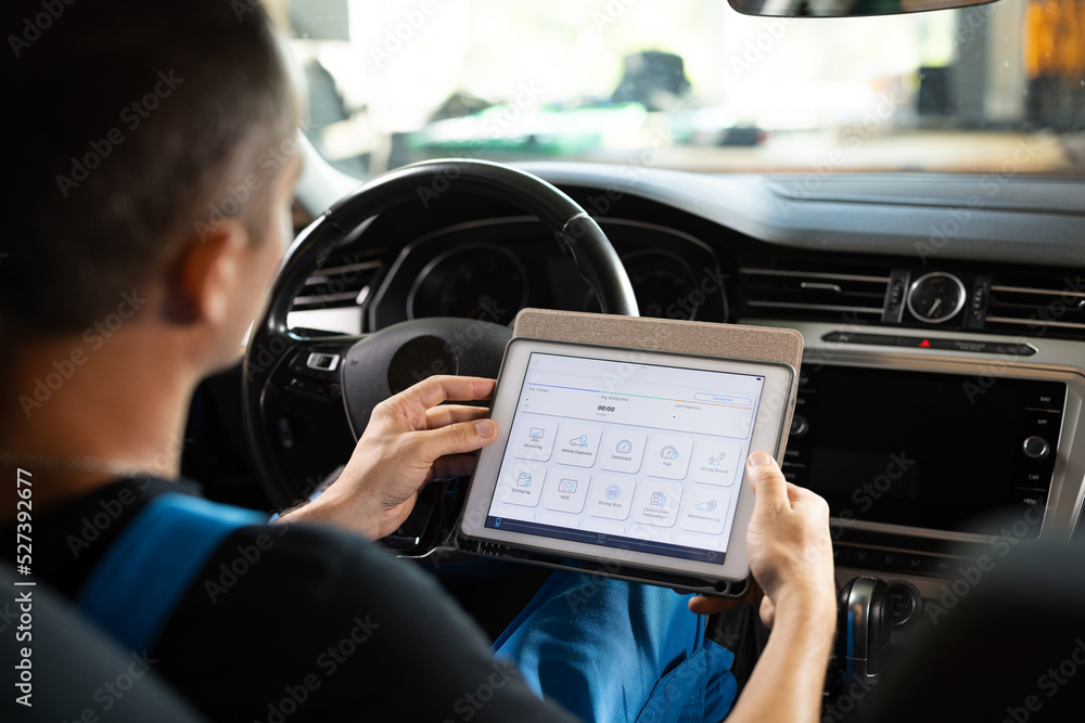Unrecognizable vehicle service manager worker work in mechanics garage, check and maintenance to repair the engine car in workshop. Automotive mechanic running diagnostics software on tablet Unrecognizable vehicle service manager worker work in mechanics garage, check and maintenance to repair the engine car in workshop. Automotive mechanic running diagnostics software on tablet