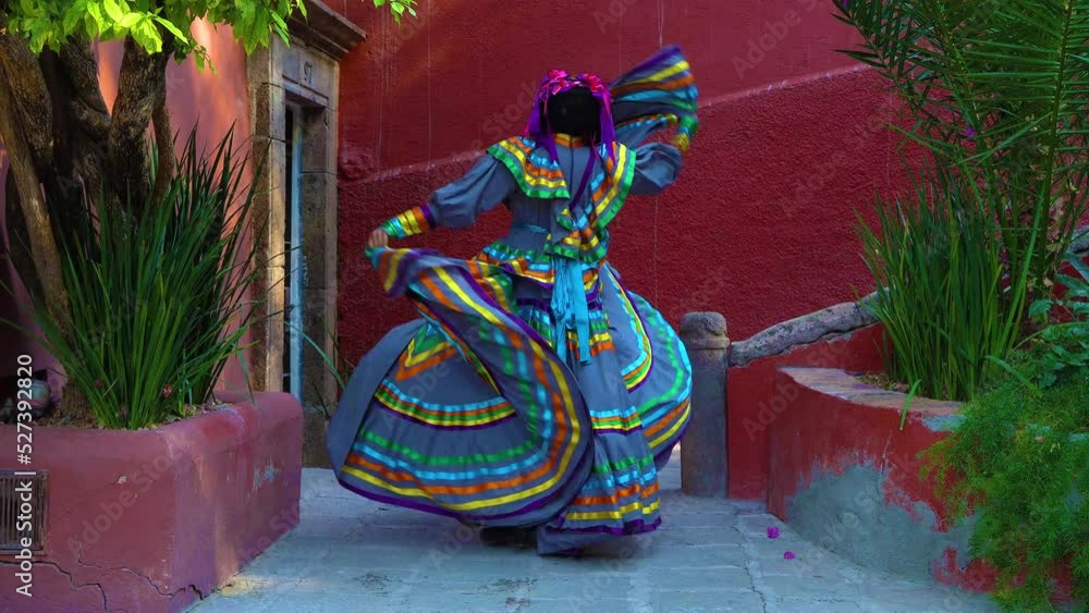 Young Mexican woman in a traditional folklore dress of many colors, traditional dancer.