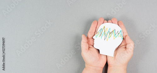 Holding a head in the hands  epilepsy disorder awareness  brain waves mental health care  paper cut out 