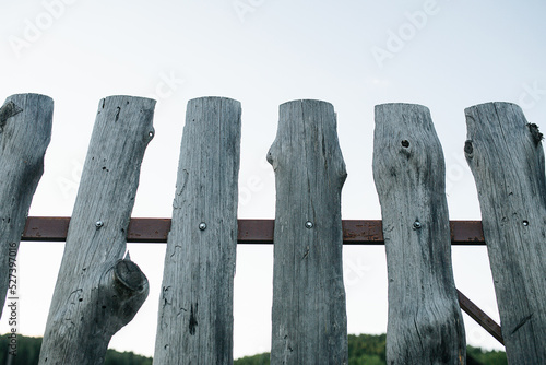 Upward angle of cheap old wooden slab fence texture on a metal frame