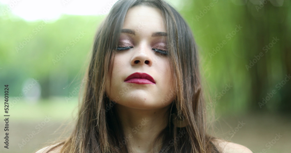 Young woman takes a deep breath outside, meditative pretty girl looking to camera feeling lungs with air Young woman takes a deep breath outside, meditative pretty girl looking to camera feeling lungs with air