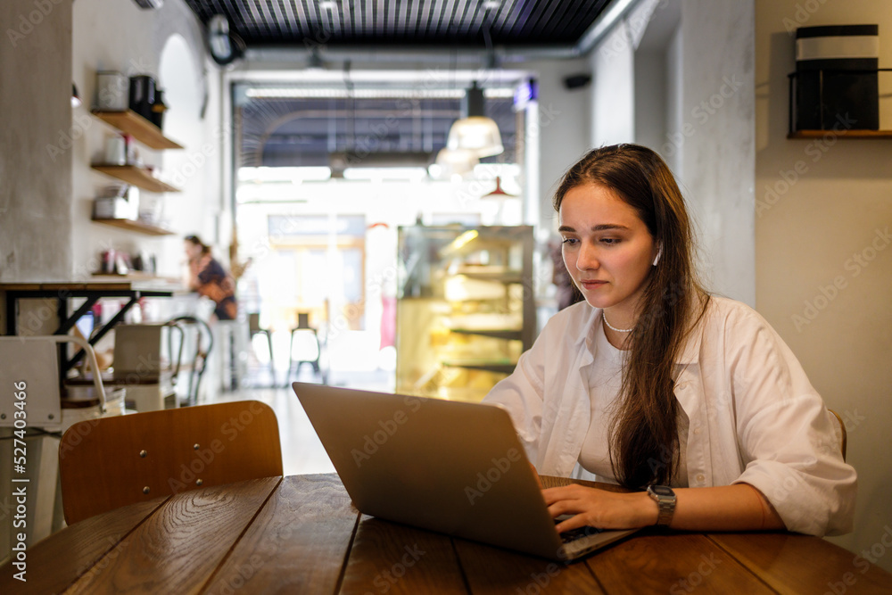 Young woman in white shirt using her laptop for online education