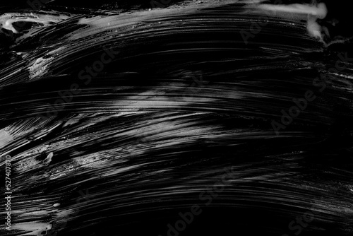 Soap foam spread with bubbles isolated on black texture, top view
